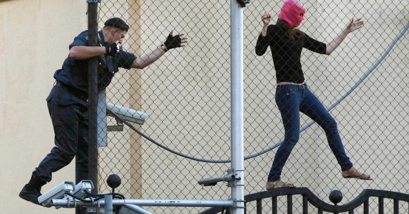 A police officer attempting to seize a Pussy Riot supporter